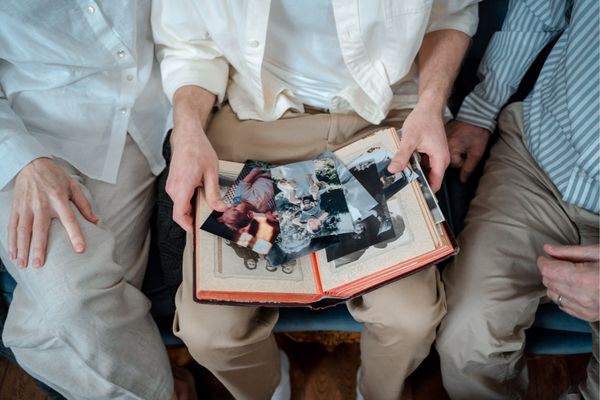 Multiple generations holding family pictures from above