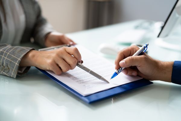 Someone signing a document at a desk